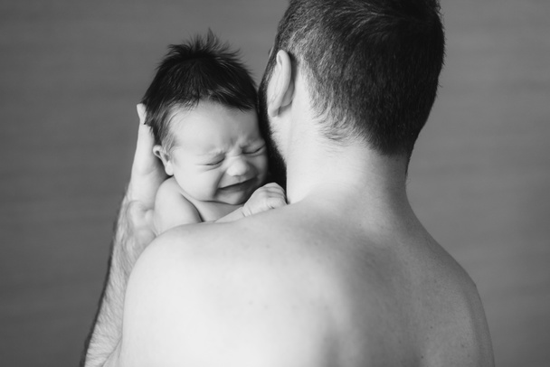 Babyjongen huilen op de schouder van zijn vader - Foto, afbeelding