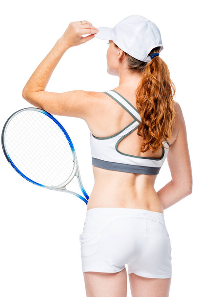 Girl sportswoman with back in frame corrects cap isolated  - Foto, imagen