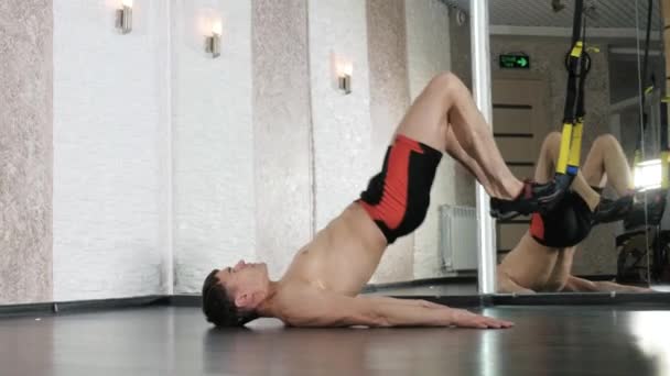Man is engaged in trx exercises in the studio 4k - Imágenes, Vídeo