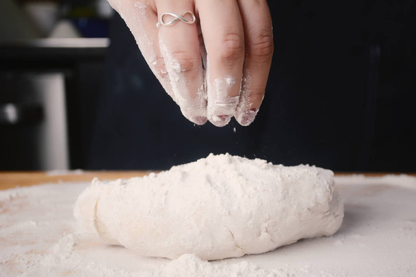 Woman hand adding flour to dough. - Valokuva, kuva