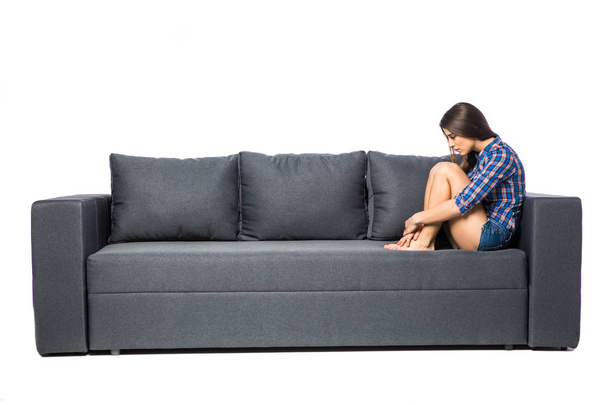 Sad depressed woman at home, she is sitting on the couch, loneliness and sadness concept - Foto, Bild