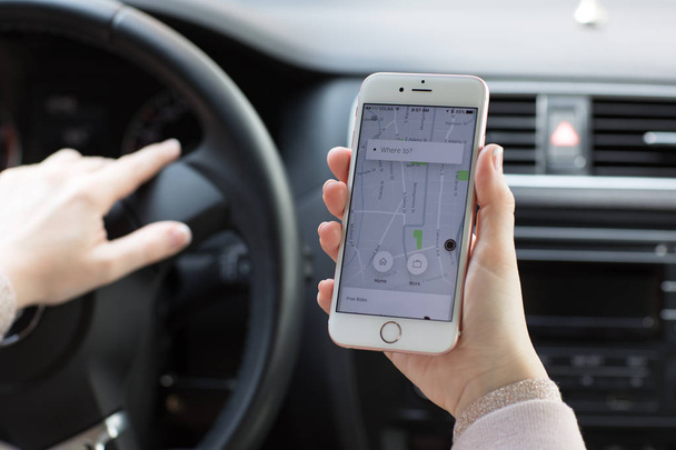 Woman hands holding iPhone 6S with application Taxi Uber - Fotó, kép