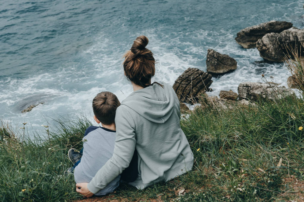 Hipster Mother and her son watching a crashing waves at sea, Mon - 写真・画像