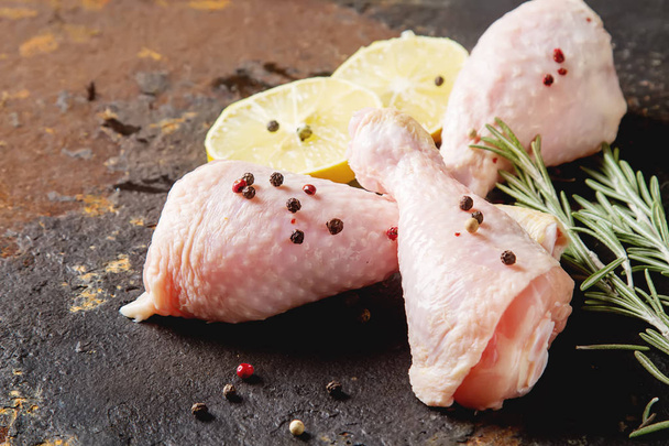 Chicken legs with rosemary, pepper and lemon. Dark background. L - Zdjęcie, obraz