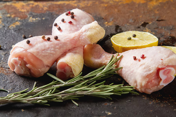 Chicken legs with rosemary, pepper and lemon. Dark background. L - Foto, afbeelding