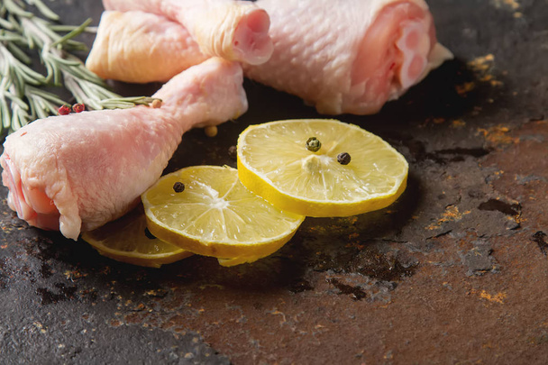 Chicken legs with rosemary, pepper and lemon. Dark background. L - Zdjęcie, obraz
