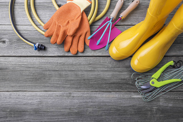 Rubber boots and garden tools. - 写真・画像