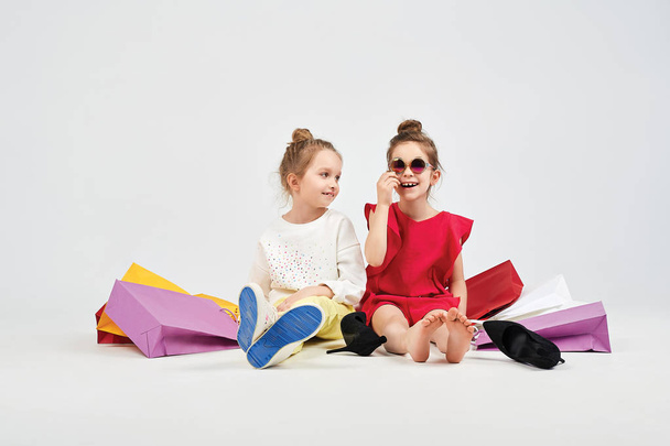 Dressed up girls are sitting around shoppers bags - Foto, Imagem