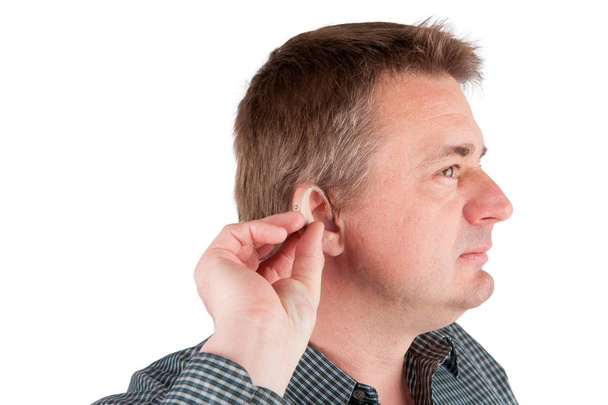 Homem inserindo um aparelho auditivo no ouvido
 - Foto, Imagem