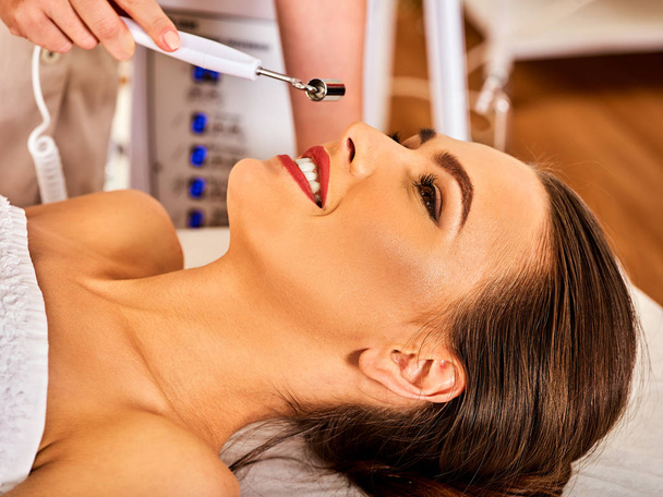 Masaje facial en el salón de belleza. Estimulación eléctrica mujer cuidado de la piel
. - Foto, imagen