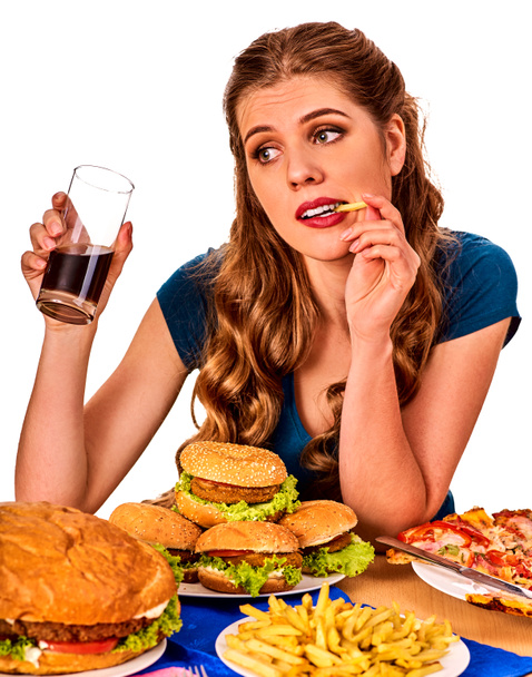 Woman eating french fries and hamburger. - Photo, Image