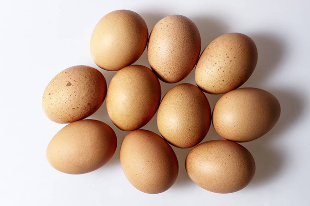 Huevos de pollo sobre fondo blanco, vista desde arriba
 - Foto, imagen