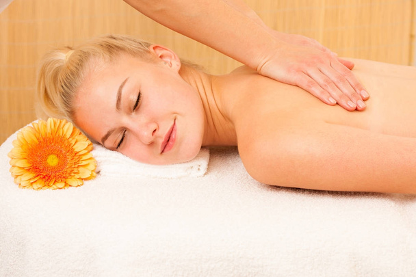 Beautiful blonde woman enyoing massage treatment in sap salon - Photo, Image