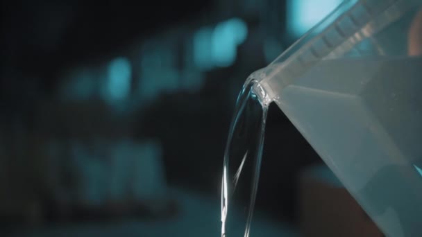 Agua clara vertiendo lentamente cubo de plástico transparente cuadrado
 - Metraje, vídeo