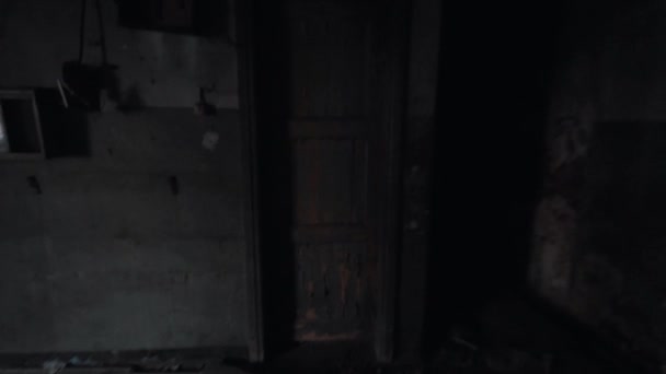 Point of view male feet kicks door leading into darkness in abandoned building - Footage, Video