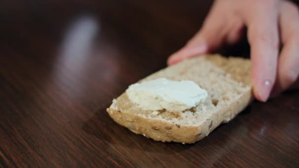 Vrouwelijke handen verspreiding van boter op brood - Video