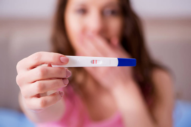 陽性の妊娠検査を発見した女性 - 写真・画像