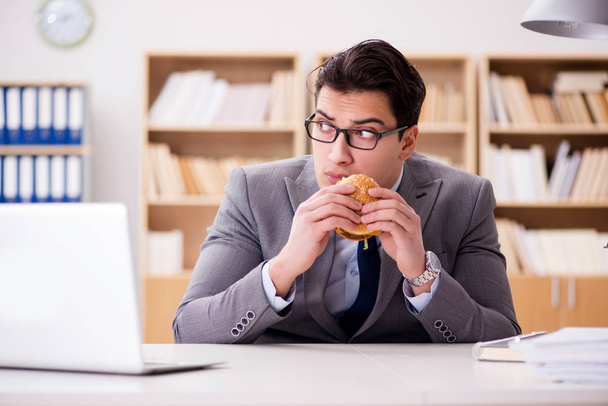 Hambriento empresario divertido comer sándwich de comida chatarra - Foto, Imagen