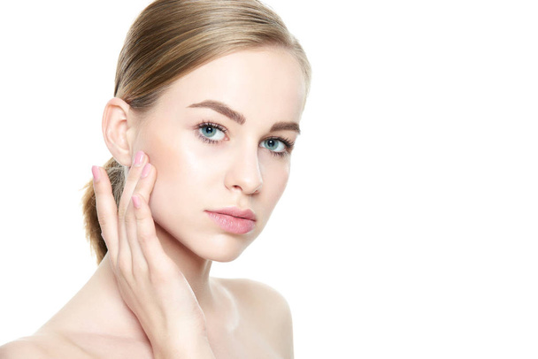 Beautiful Young Blond Woman with Perfect Skin touching her face. Facial treatment. Cosmetology, beauty and spa concept. Isolated on white background. - Foto, imagen