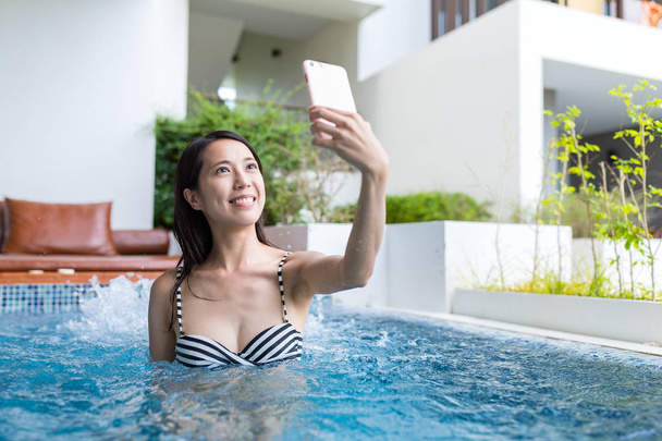 Woman enjoy in jacuzzi spa and taking selfie - Foto, Imagen