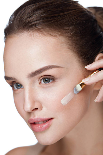 Beauty. Beautiful Woman Applying Foundation With Cosmetic Brush - Foto, afbeelding