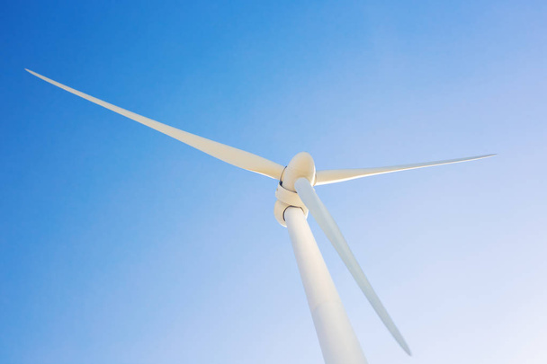 Turbina eolica che genera elettricità con cielo blu - concetto di risparmio energetico - Foto, immagini