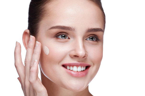 Mooie vrouw crème Base toe te passen op schoonheid gezicht huid - Foto, afbeelding