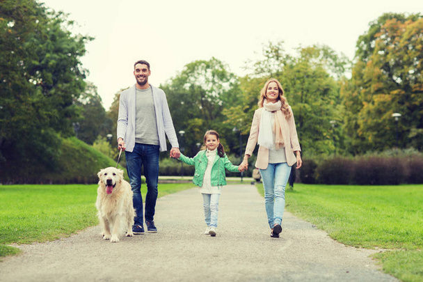 happy family with labrador retriever dog in park - Foto, Bild