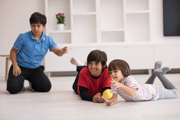 boys having fun with an apple on the floor - Φωτογραφία, εικόνα