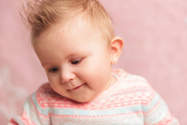 babymeisje glimlachend neerkijkt aan zijkant - Foto, afbeelding