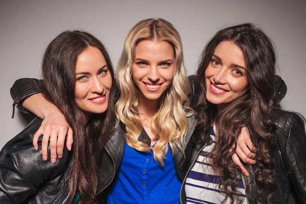 três gargalhadas jovens mulheres em jaquetas de couro
 - Foto, Imagem