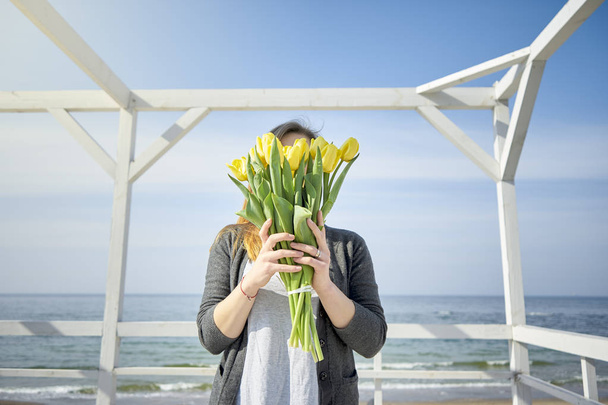 La ragazza si copre il viso di tulipani gialli
 - Foto, immagini