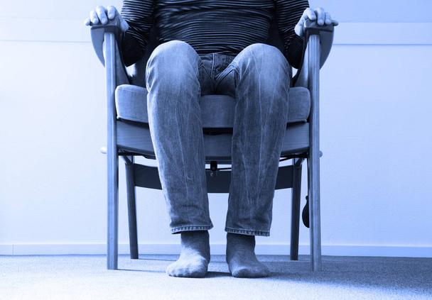 Mann im Sessel, leicht gruselig  - Foto, Bild
