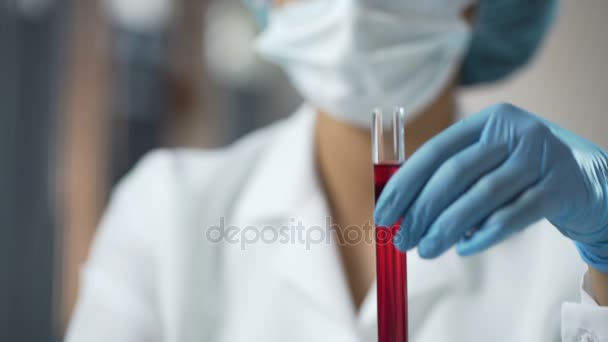 Cientista segurando dois tubos de ensaio com líquido vermelho, azul no laboratório, pesquisa
 - Filmagem, Vídeo