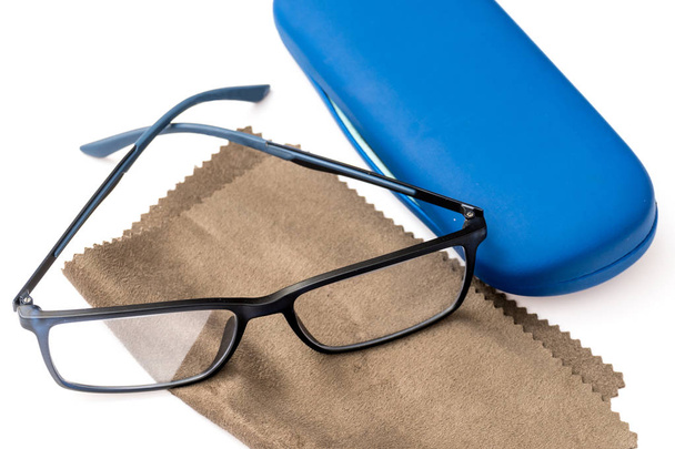 Lendo óculos pretos, pano de limpeza de microfibra marrom e caixa protetora azul isolada em branco
 - Foto, Imagem
