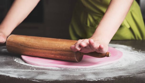 Woman using rolling pin preparing royal icing for cake decorating, hands detail - Foto, afbeelding