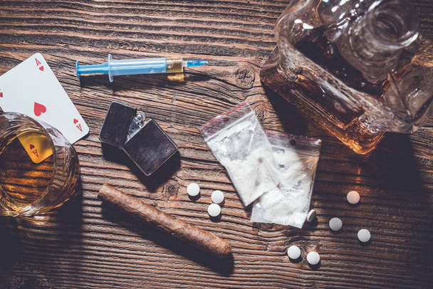 Addiction concept. Hard drugs and alcohol on wooden table - Photo, image