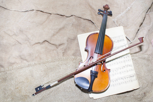 Cuello de violín sobre fondo de papeles musicales
 - Foto, Imagen