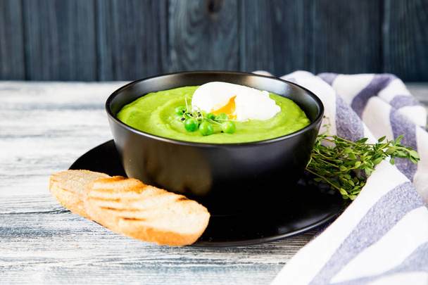 Zelfgemaakte puree soep met doperwtjes en micro greens.  - Foto, afbeelding