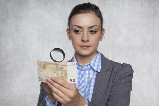 Young business woman checks the authenticity of money - Zdjęcie, obraz