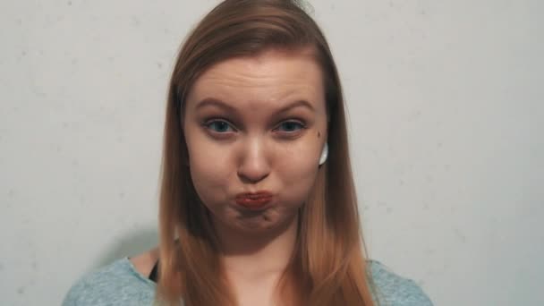 Αστεία νεαρή κοπέλα σε γκρι μπλούζα με αυτί σήραγγες κατέχει αναπνοή φυσά-επάνω τα μάγουλα - Πλάνα, βίντεο