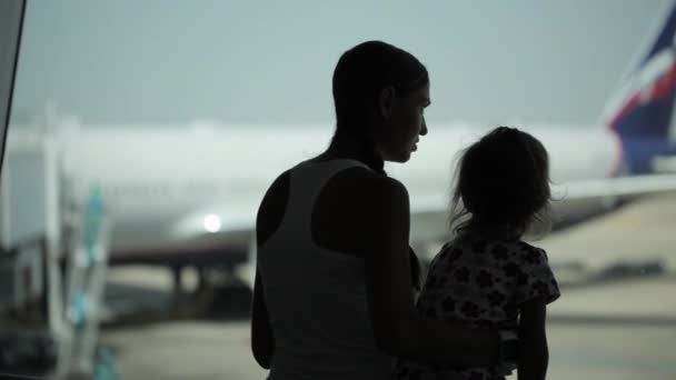 Silhouettes of mother ahd daughter with airplane on the background - Séquence, vidéo