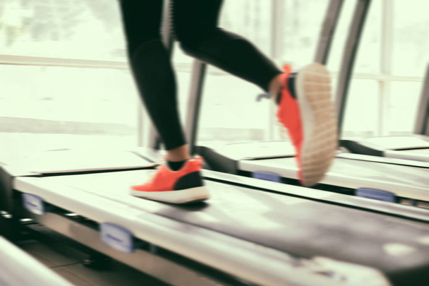 Blurry de chaussures de sport de course à la salle de gym alors qu'une jeune caucasie
 - Photo, image