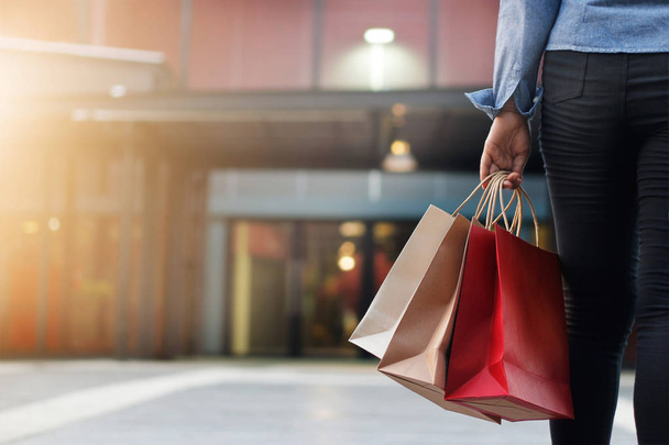mujer caminando con bolsas de compras en la mano en el fondo del centro comercial
. - Foto, imagen