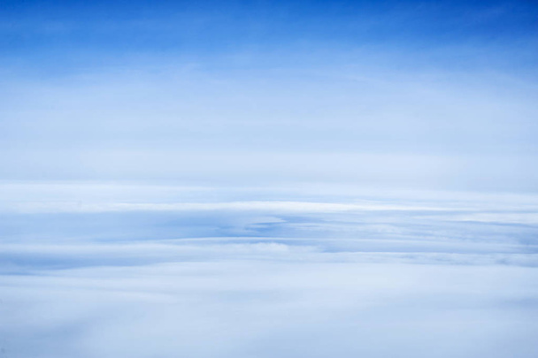 Felhők és ég a repülőgép ablakán keresztül. - Fotó, kép