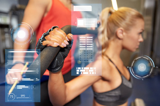 man and woman flexing muscles on gym machine - Photo, image