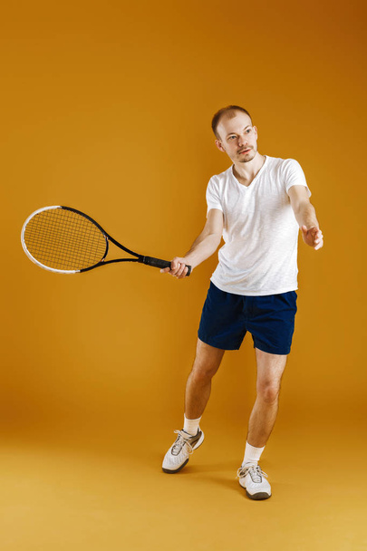young tennis player plays tennis on yellow background - Zdjęcie, obraz