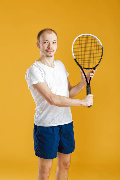 young tennis player plays tennis on yellow background - Фото, зображення