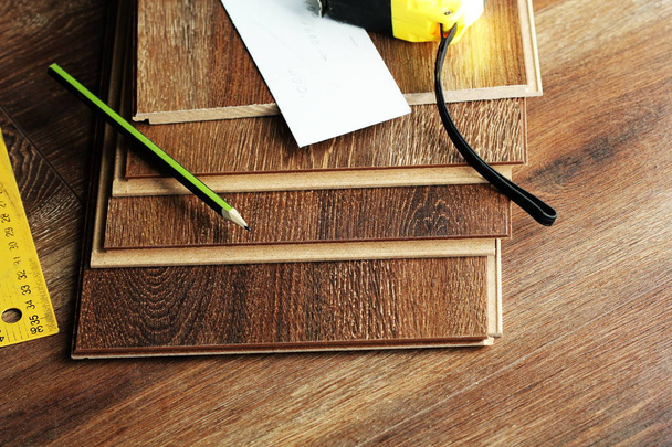 Ламинированные напольные доски и инструменты на деревянном фоне
 - Фото, изображение