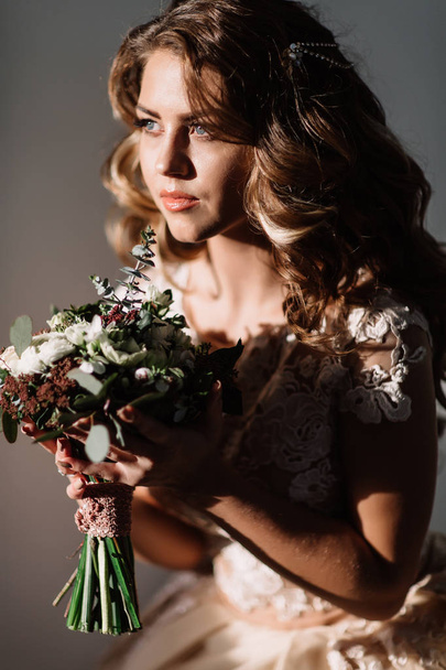 bride with bouquet in hand in a beautiful dress - Foto, Imagen